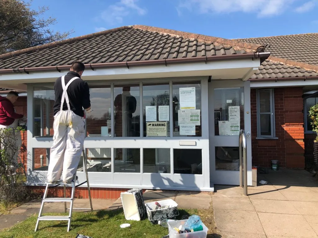 A decorator working on the exterior walls